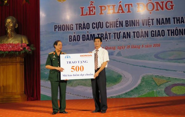 Ông Phùng Văn Huệ - Trưởng Khối LXAT Cty Honda VN trao tặng biển tượng trưng 500 mũ bảo hiểm cho đại diện hội Cựu chiến binh Việt Nam